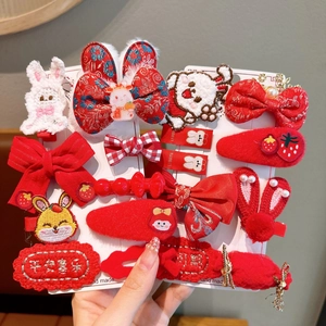 Detailed view of red festive hair clips with rabbit embroidery and traditional patterns