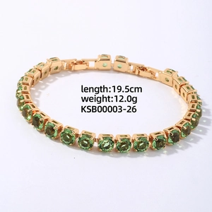 Close-up of golden tennis bracelet with green round zircons and detailed metal setting