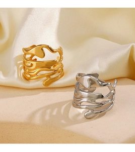Close-up of golden and silver irregular molten liquid metal rings on silk background