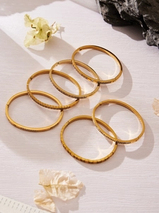 Dettaglio di bracciali geometrici in acciaio inossidabile placcato oro 18k con zirconi