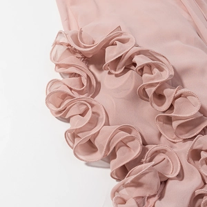 Detail of delicate tiered ruffle edges in soft dusty pink chiffon fabric