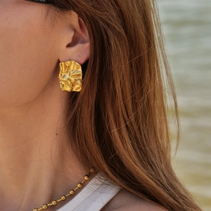 Minimalist square crinkle earrings in gold titanium steel shown on a female model