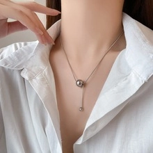 Detail of silver titanium square snake chain necklace with round pendant on model