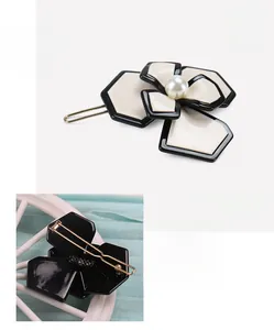 Detail of cellulose acetate camellia hair clip with pearl and golden back clip