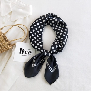 French retro style black and white polka dot silk square scarf tied in a bow on a white shirt