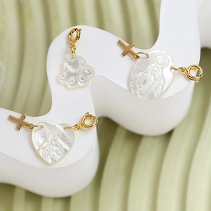 Mother of pearl heart and cat paw charms with gold-plated religious relief and spring clasp