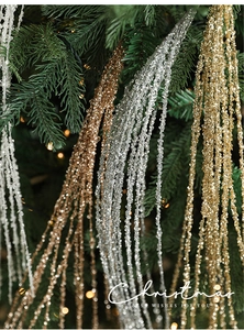 Detail van glinsterende kerst-lovertjes kwastjes takken in goud en zilver decoratie