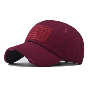 Close-up of distressed vintage wine red cotton baseball cap with American flag embroidery