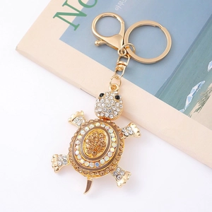 Close-up of golden turtle keychain featuring sparkling rhinestones and lobster clasp