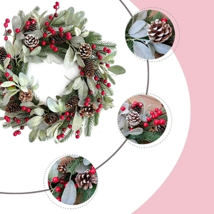 Christmas wreath with green pine needles, red berries, pine cones and flocked leaves