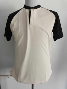 Dettaglio della polo a nido d'ape a maniche corte con design bicolore crema e nero