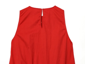 Détail d'une robe rouge sans manches avec col rond et fermeture à bouton au dos