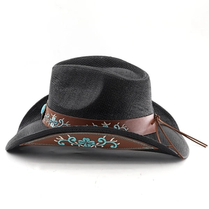 Detail of black straw cowboy hat with turquoise floral embroidery on brown leather band