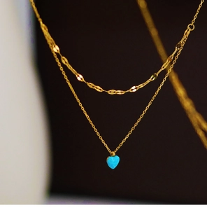 Macro view of double-layered 18K gold plated necklace with blue heart opal pendant