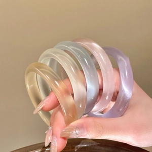 Set di quattro bracciali geometrici in vetro traslucido nei toni ambra, crema e lilla