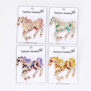 Macro detail of horse brooches set with crystal rhinestones in four vibrant colors