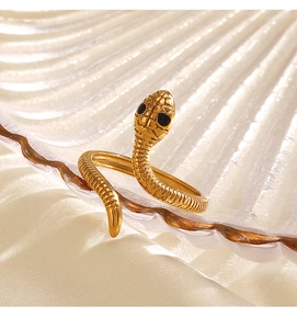 Dettaglio anello a serpente dorato con squame testurizzate e occhi in pietre nere