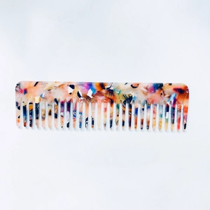 Macro detail of wide-tooth acetate comb with colorful marble terrazzo pattern