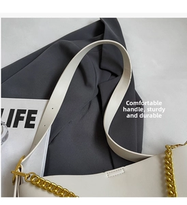 Detail of adjustable leather strap and chunky gold chain on beige tote bag