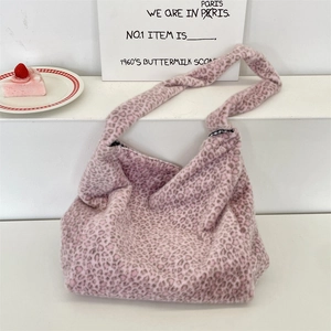 Detailed close-up of pink leopard print plush tote bag on a white display stand