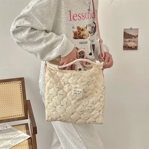 Quilted beige canvas bag featuring cute cartoon bear prints and colorful braided handles