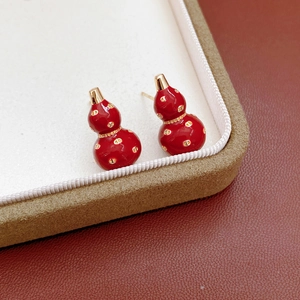 Detailed macro view of 18k gold plated red enamel gourd earrings in a premium jewelry box