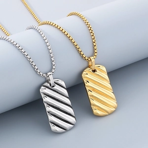 Macro detail of gold and silver square wave texture pendants with box chains for men