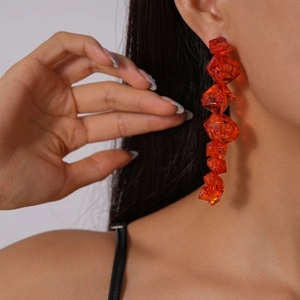 Close-up of orange geometric acrylic bead earrings worn by a professional model