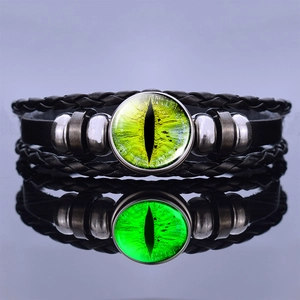 Macro shot of steampunk dragon eye glowing leather bracelet with green glass cabochon