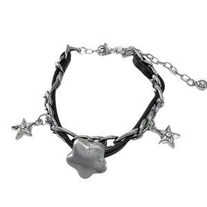 Close-up of Y2K star charm bracelet with silver metal chain and black leather strap
