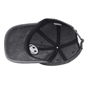 Detail of the smile patch embroidery and reinforced seams inside the washed cotton baseball cap