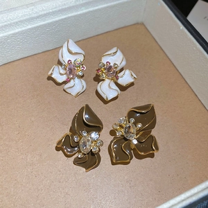 Detail of floral earrings with colorful gemstones and enamel finish in display box
