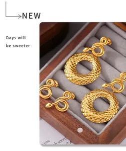 Détail de boucles d'oreilles serpent plaquées or 18k dans un écrin à bijoux de luxe