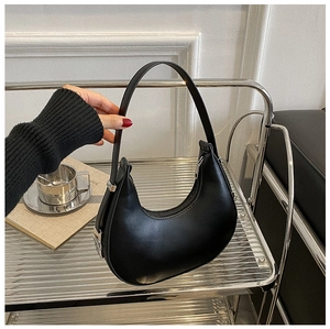 Detailed shot of a black leather crescent hobo bag with silver buckle and sleek zipper