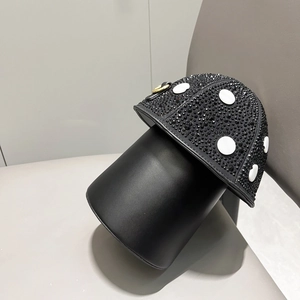 Detail of mushroom shaped handbag featuring black rhinestones and gold ring pull