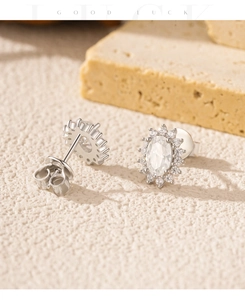 Gros plan de boucles d'oreilles halo en argent avec moissanite ovale et fermoir papillon