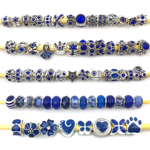 Detail of blue themed DIY alloy charm beads with star and heart patterns on yellow sticks