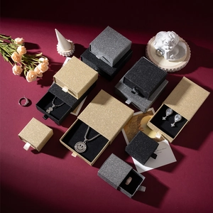 Detailed view of glitter drawer jewelry boxes in gold, silver and black with ribbon pulls