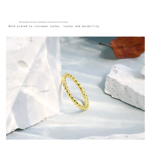Detail of twisted rope gold-plated ring showing textured finish and scratch resistance
