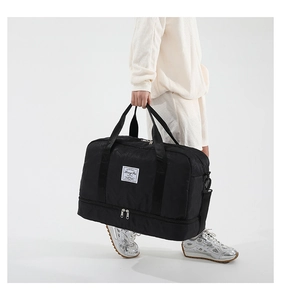 Detail of black sports gym bag showing the separate bottom shoe compartment for travel