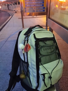 Mint green backpack with a detailed baseball glove, ball, and wooden bat keychain