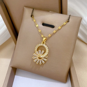 Macro detail of gold flower pendant necklace with cubic zirconia on a leather display