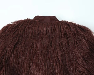 Detail of dark burgundy faux fur coat with ribbed knit collar and long fringe textures