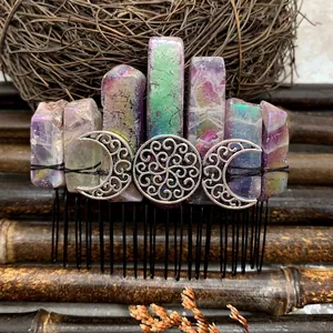 Macro shot of aura quartz hair comb with silver crescent moon detail and black metal pins