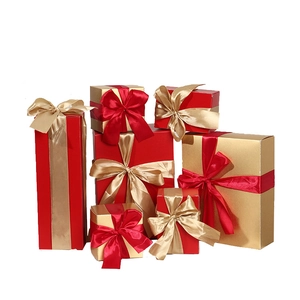 Stack of Christmas gift boxes with red and gold ribbons in various sizes on white background