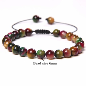 Macro shot of 6mm tiger eye stone beads on an adjustable woven bracelet with stone texture