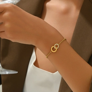Chic gold-plated interlocking circles bracelet with pavé-set crystals on elegant female wrist