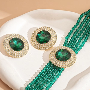 Vintage green crystal jewelry set with sparkling rhinestones on an elegant stone tray