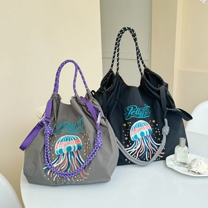 Detail of waterproof nylon tote bag with jellyfish embroidery and woven rope handles