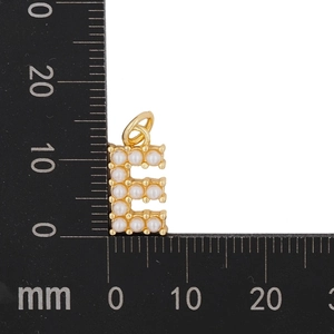 Macro shot of gold letter E pendant with pearls next to a ruler showing its 15mm size